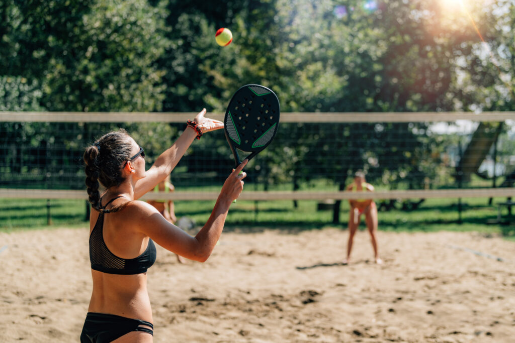 Mulher jogando beach tennis na quadra de areia do Solares Residencial & Clube em Capivari (SP). A imagem destaca a estrutura esportiva e de lazer diferenciada do condomínio fechado planejado pela Forner Empreendimentos (imagem meramente ilustrativa). Uma excelente oportunidade para quem busca comprar terrenos e lotes residenciais prontos para construir, oferecendo qualidade de vida e esporte para moradores de Capivari e de cidades vizinhas como Rafard, Mombuca, Elias Fausto, Monte Mor, Porto Feliz, Rio das Pedras e Santa Bárbara d'Oeste.